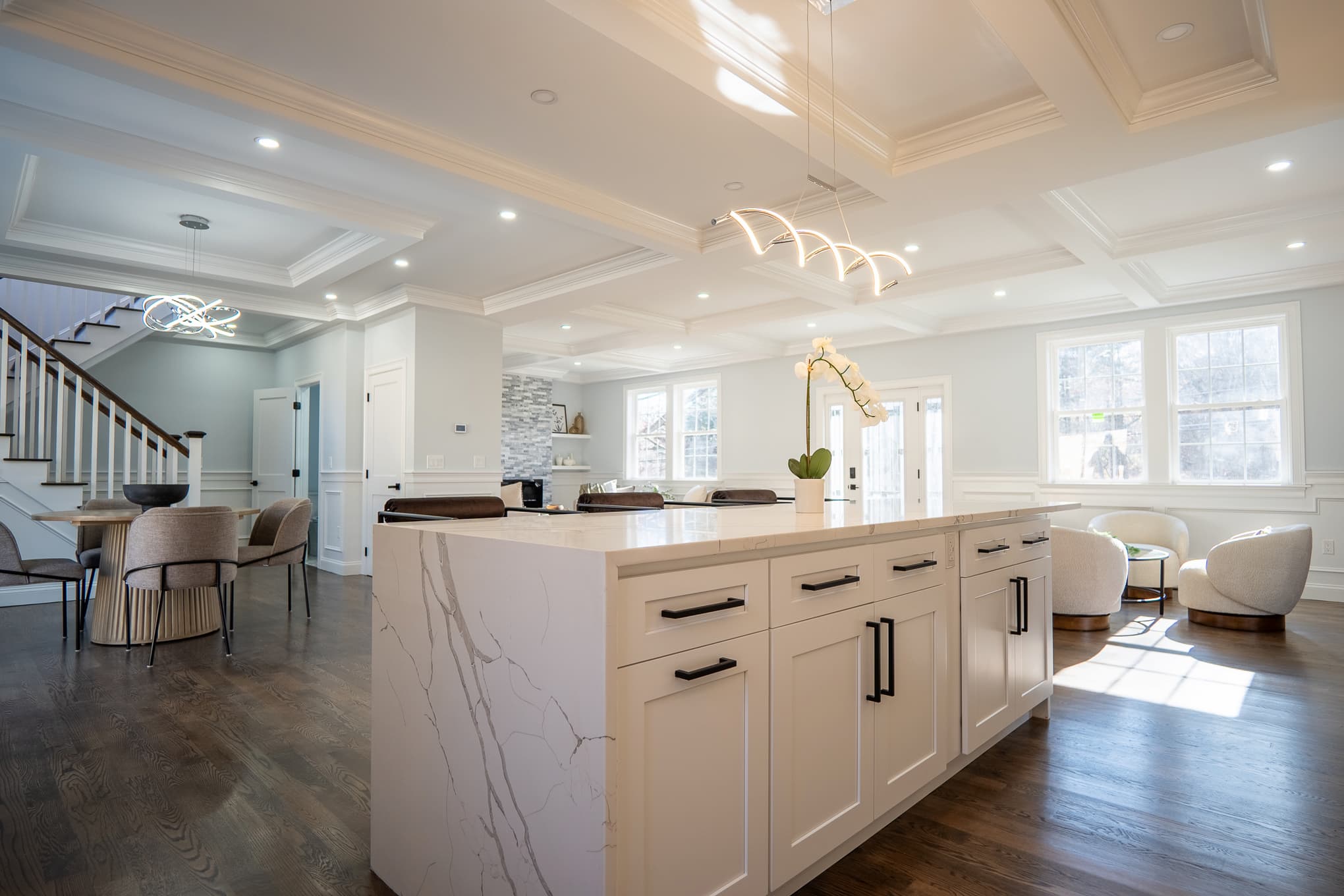 Modern kitchen featuring a spacious island and elegant staircase, showcasing a stylish home remodeling design.