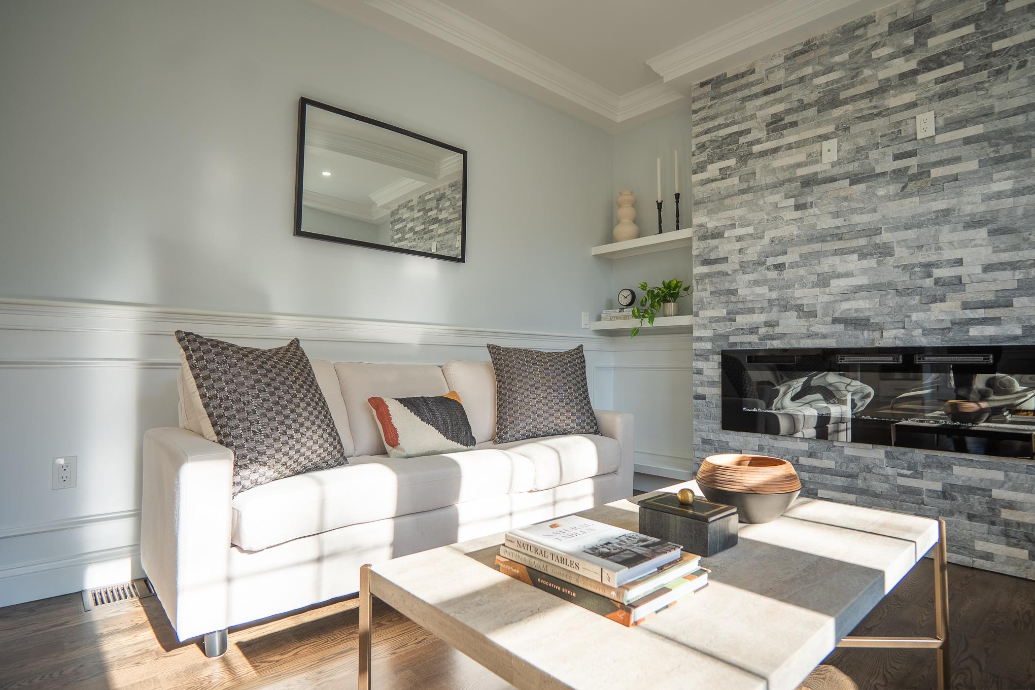 A sophisticated living room featuring a cozy fireplace and an elegant couch, showcasing exquisite design elements. by a professional interior designer.